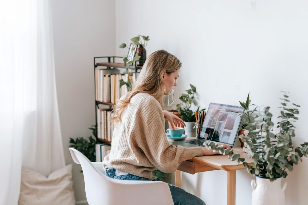 woman seated at desk looking at computer