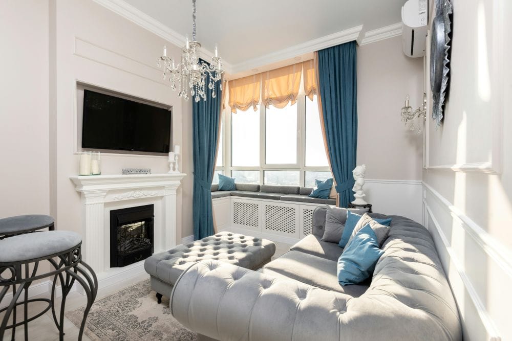 window treatment room with couch, fireplace and window curtains featuring home decor