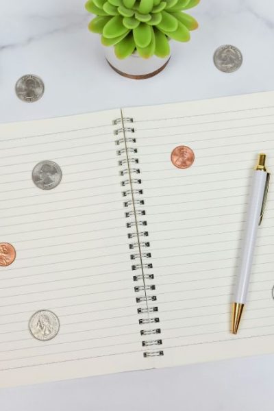 notebook with pen, coins and cash