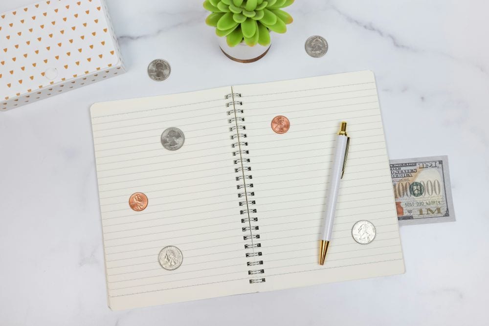notebook with pen, coins and cash