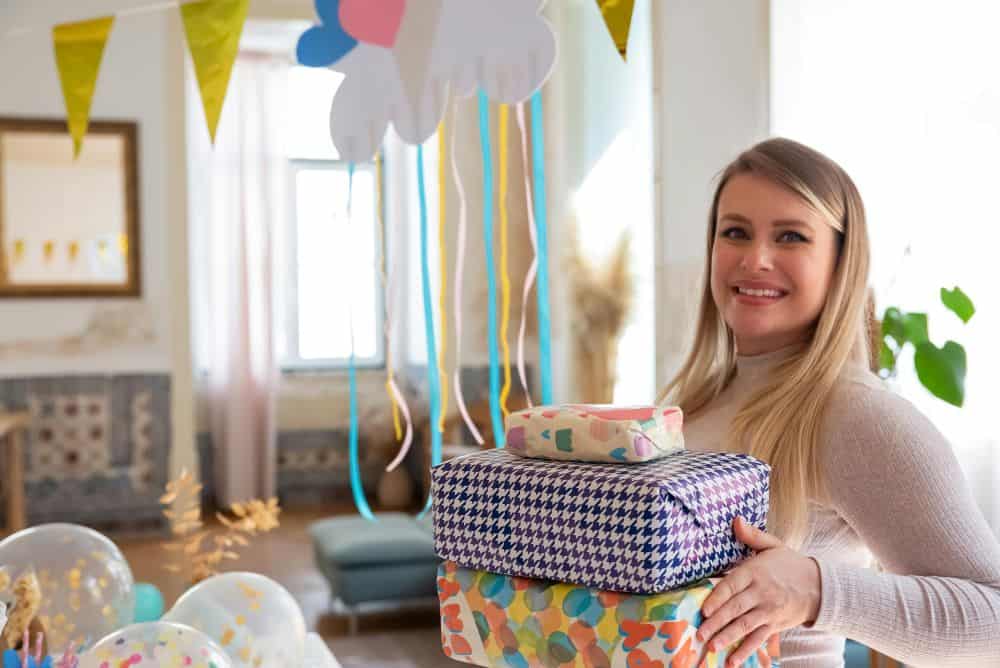 woman holding several wrapped gifts