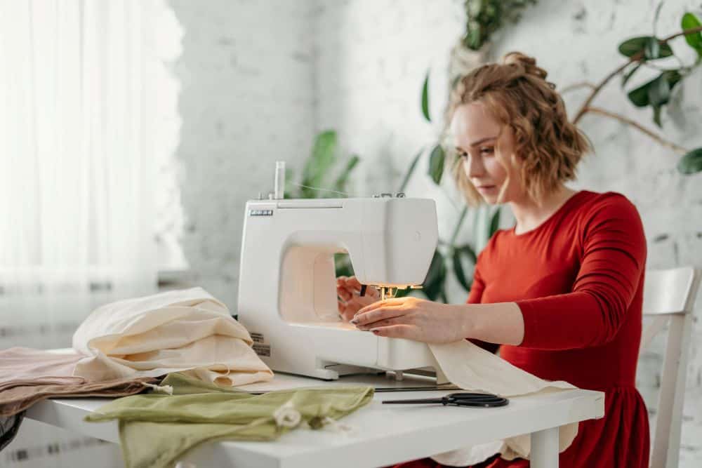 woman at sewing machine repairing clothes