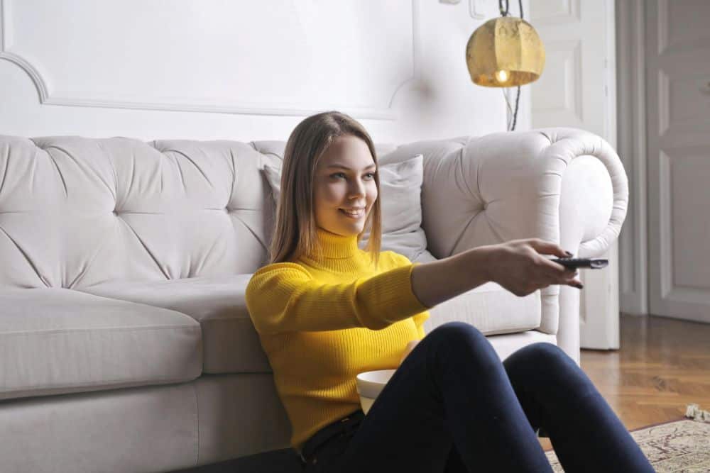 woman with remote control watching tv