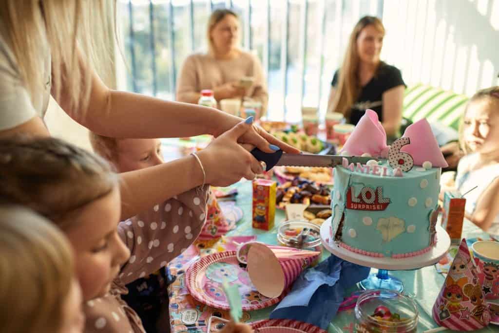 Photo by Edvinas Ivanovas a group of people sitting around a table with a cake