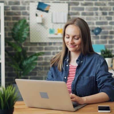 a woman sitting at a desk using a laptop computer