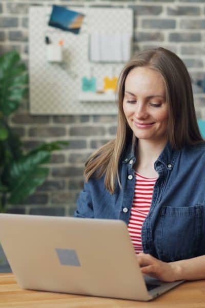 a woman sitting at a desk using a laptop computer