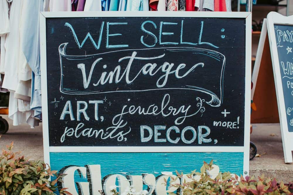 sign featuring text reading "we sell vintage, art, jewelry, plants decor and more"