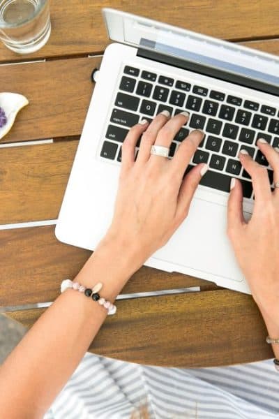 overhead view of hands typing on a laptop