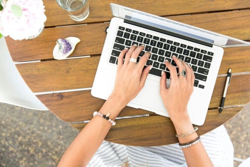 overhead view of hands typing on a laptop