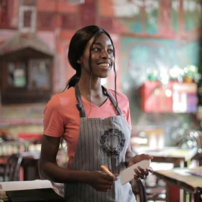 girl with apron on working in restaurant