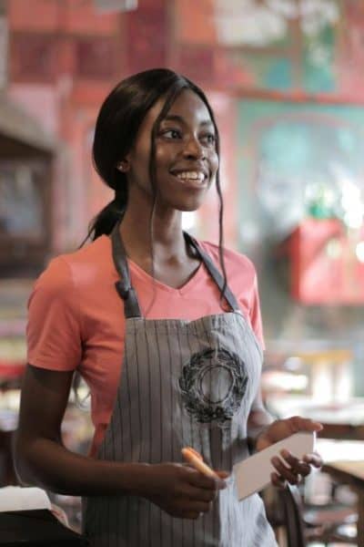 girl with apron on working in restaurant