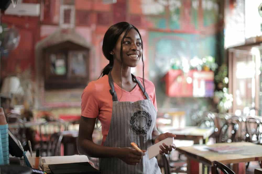 girl with apron on working in restaurant