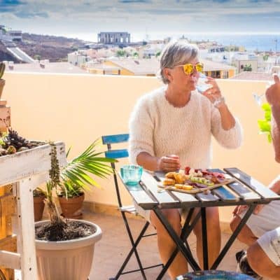 older couple sitting at table with food and drinks enjoying retirement