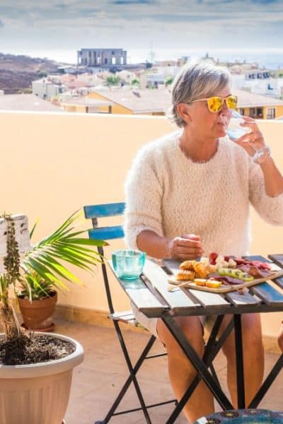 older couple sitting at table with food and drinks enjoying retirement