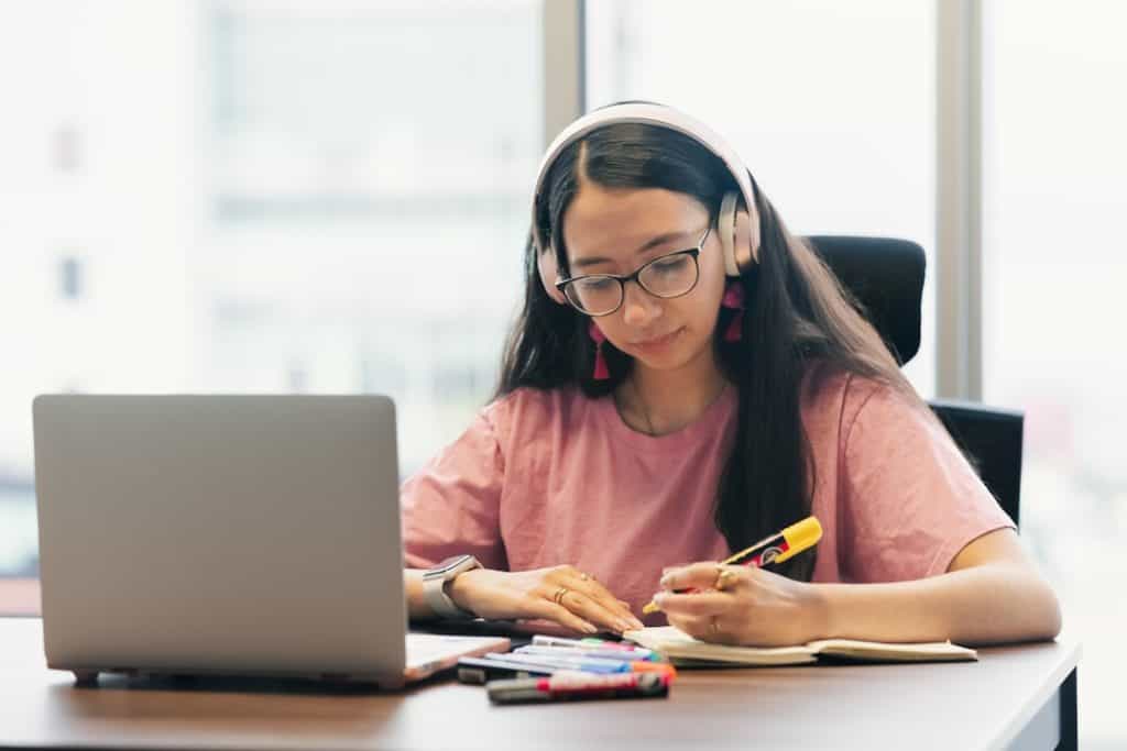 online course girl on laptop Young woman wearing headphones studying at desk