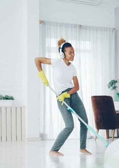 woman cleaning room with headphones on