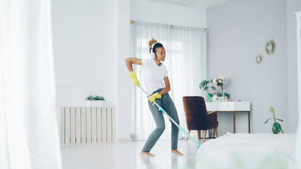 woman cleaning room with headphones on