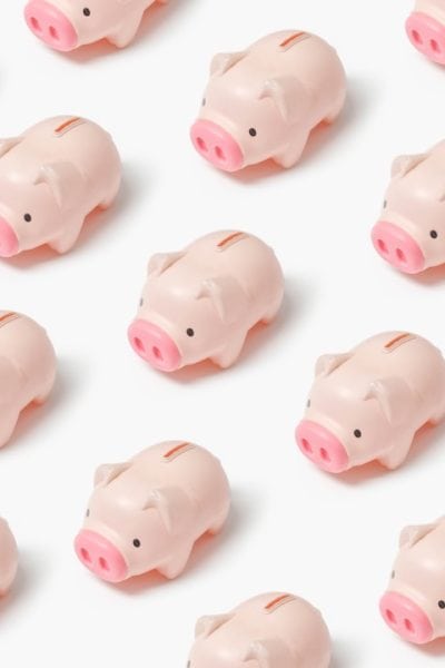 a group of small pink pig figurines on a white surface