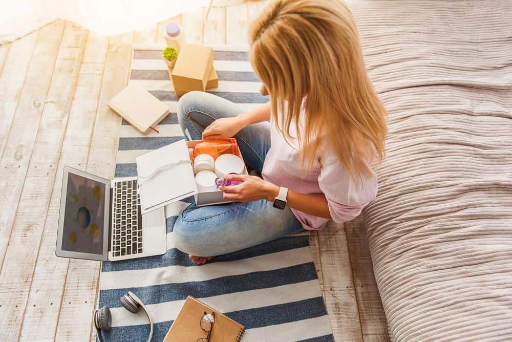 subscription box image woman sitting with a laptop and subscription box with products inside