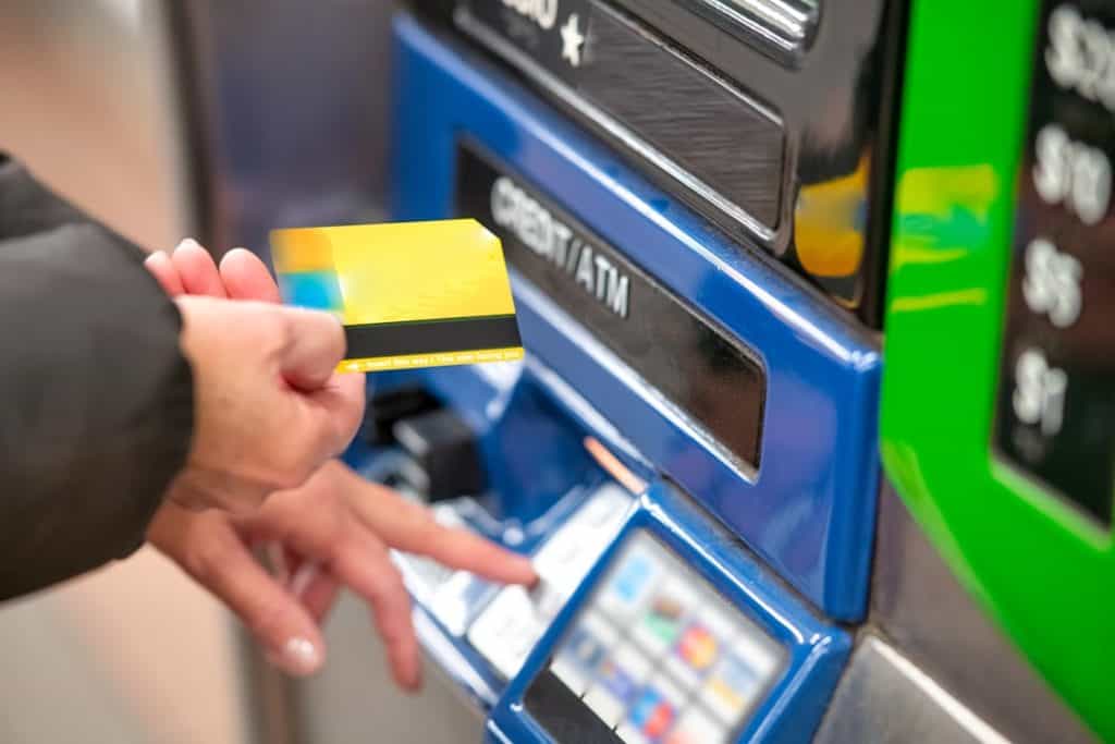 Photo by Giovanni Gagliardi a person using a credit card to pay for a machine