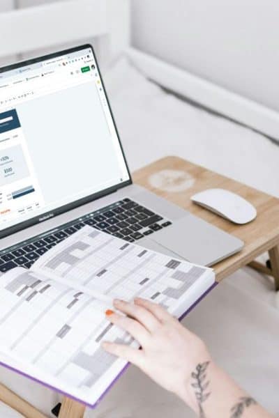 woman at computer with budget on monitor and open planning book
