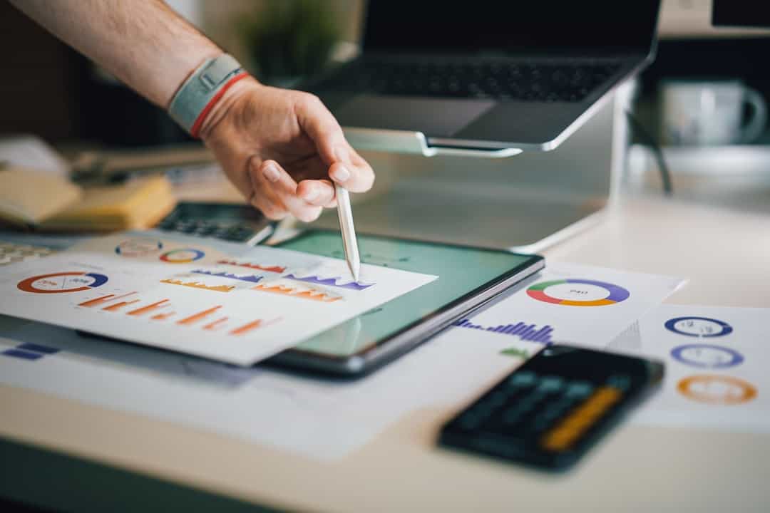 person using stylus on tablet with charts